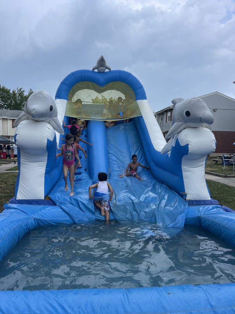 kids going down a blue and white waterslide