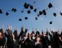 college graduates throwing caps into the air